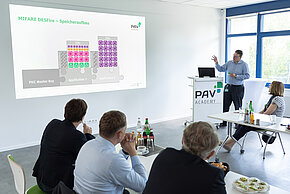 Menschen verfolgen einen Vortrag in der PAV Academy