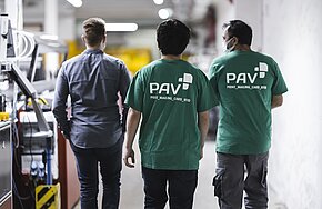 Mitarbeitende von PAV gehen durch die Produktion
